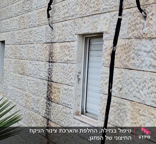 קיר חיצוני עם כבלים חשופים ליד חלון